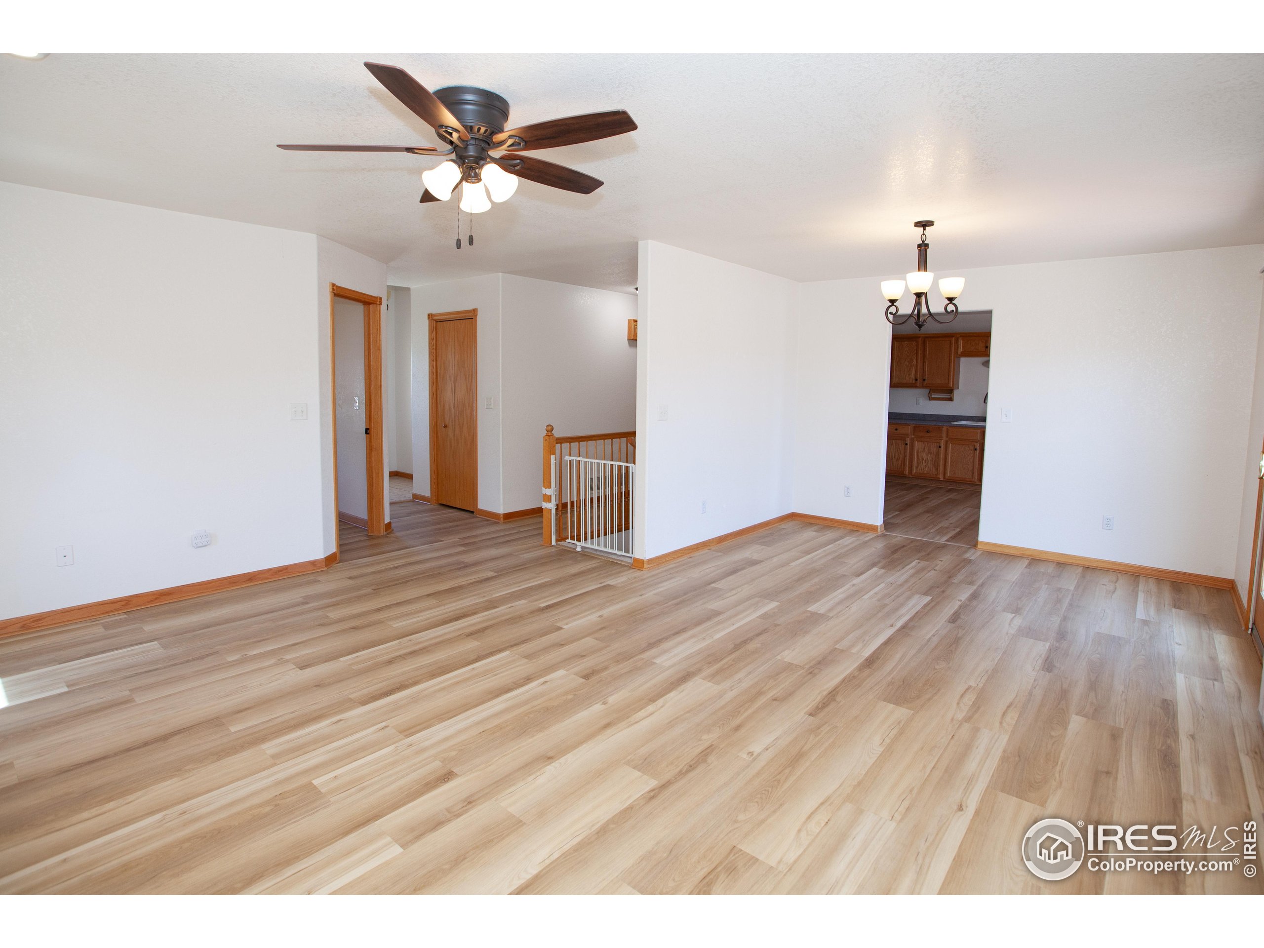 1815 Robin Road Sterling, CO 80751 - Photo 6 of 45 a view of an empty room with wooden floor and a ceiling fan