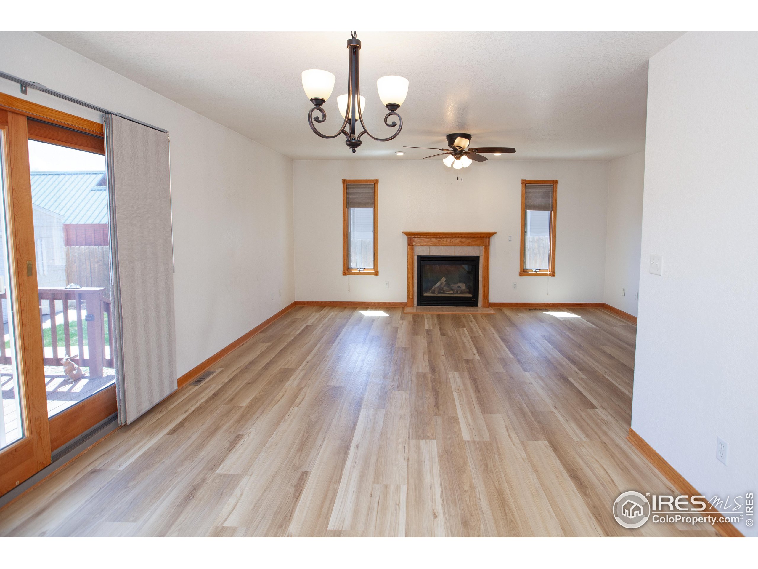 1815 Robin Road Sterling, CO 80751 - Photo 9 of 45 a view of empty room with wooden floor and fireplace