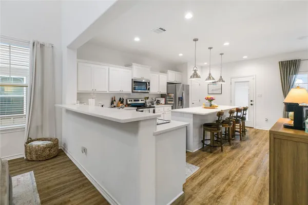 a kitchen with kitchen island granite countertop lots of counter top space and stainless steel appliances