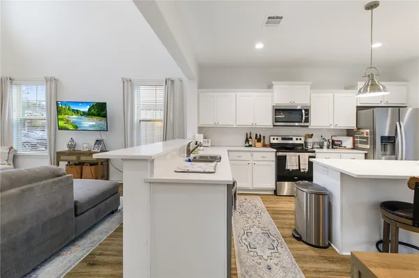a kitchen with kitchen island granite countertop a sink counter top space appliances and cabinets