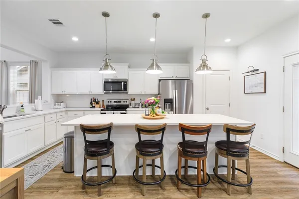 a kitchen with living room and chairs