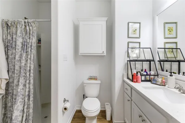 a bathroom with a toilet sink and a shower curtain