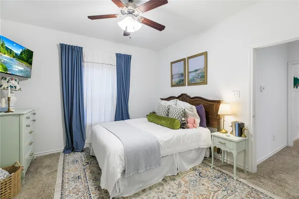 a bedroom with a bed and a flat tv screen on dresser