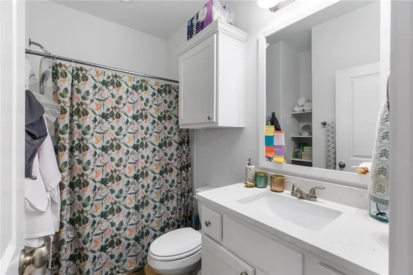 a bathroom with a sink toilet vanity and shower