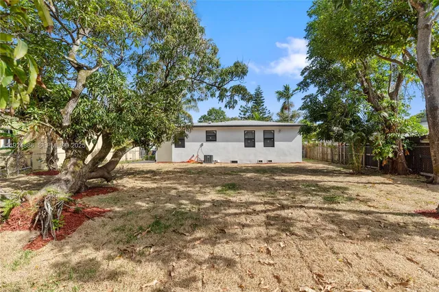 a front view of house with yard and trees around