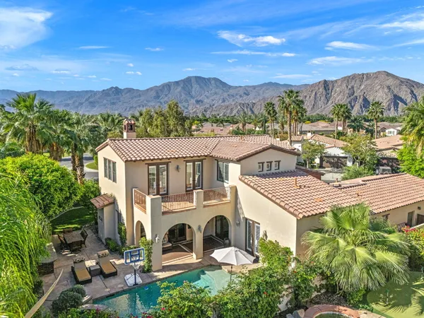 a dining room with furniture a chandelier and wooden floor