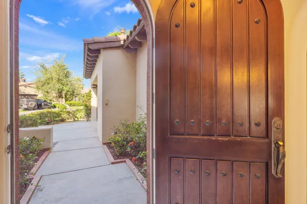 a kitchen with stainless steel appliances granite countertop a dining table chairs and a refrigerator