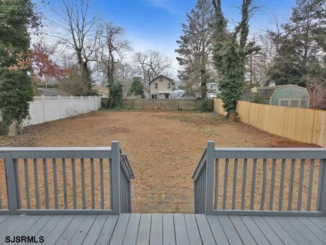 a view of a house with a small yard and wooden fence