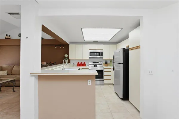 a kitchen with kitchen island a sink appliances and cabinets