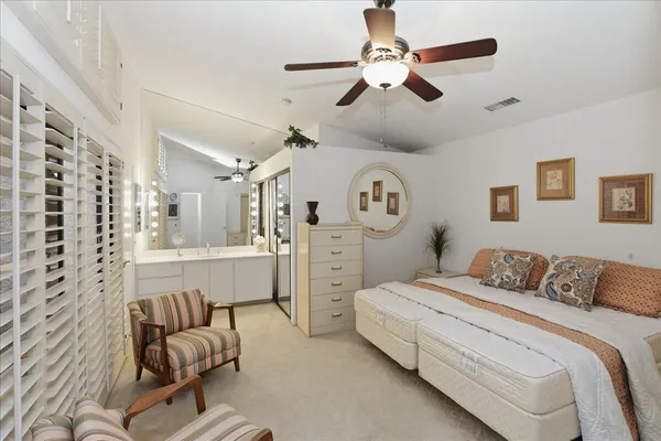 a bedroom with a bed a couch and a chandelier