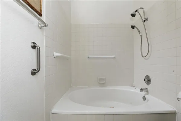 a white bath tub sitting next to a shower