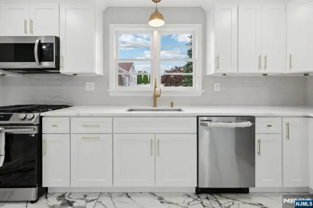 a kitchen with stainless steel appliances granite countertop a sink a stove and a microwave