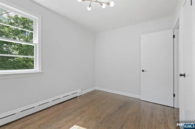 a room view with wooden floor and windows