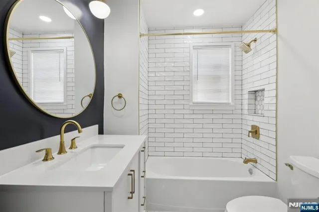 a bathroom with a sink a toilet and a mirror