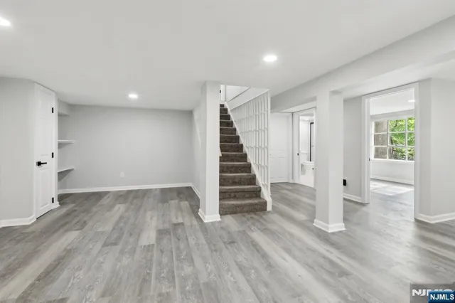 an view of an empty room with wooden floor and stairs