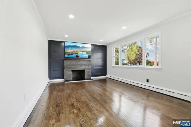 an empty room with windows and fireplace