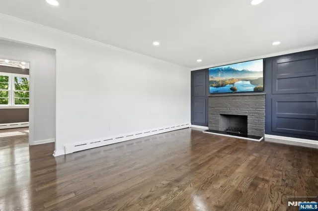 an empty room with wooden floor and fireplace