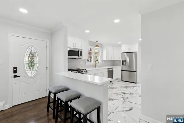 a large kitchen with stainless steel appliances a refrigerator and a stove top oven