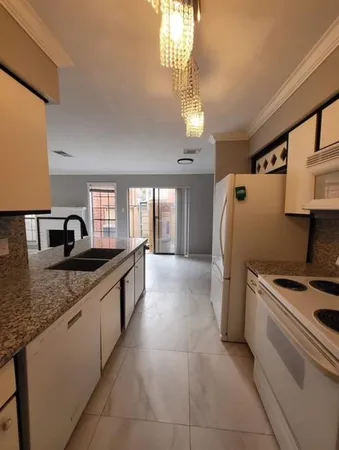 a kitchen with granite countertop a sink stove and refrigerator