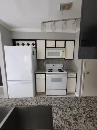 a kitchen with a refrigerator and a stove