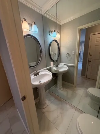 a bathroom with a sink a toilet a mirror and tub