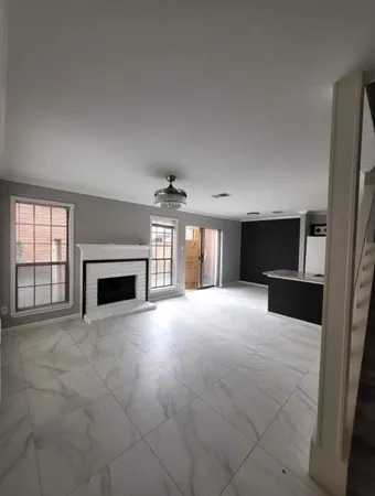 an empty room with windows and fireplace