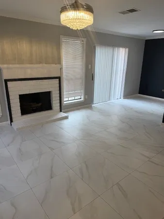 a view of an empty room with window and fireplace