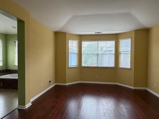 a spacious bathroom with a tub sink and mirror