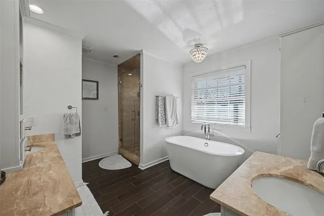 a bathroom with a double vanity sink a mirror and a bathtub