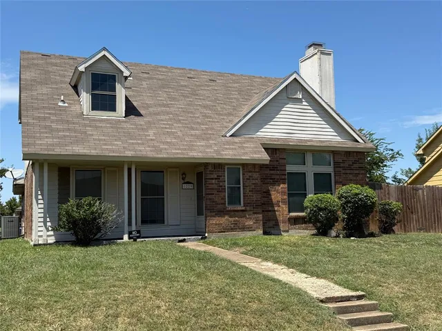 a front view of a house with a yard and plants