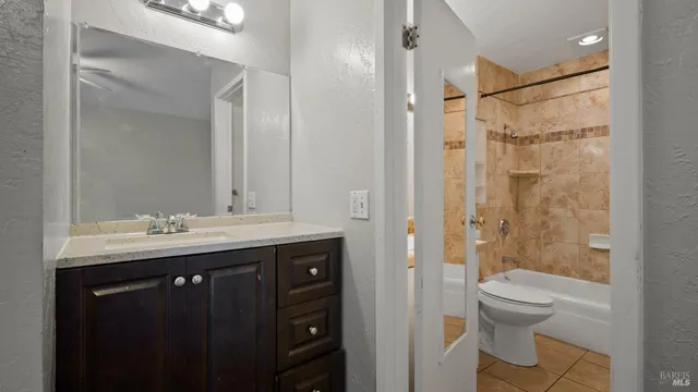 a bathroom with a granite countertop sink toilet and shower