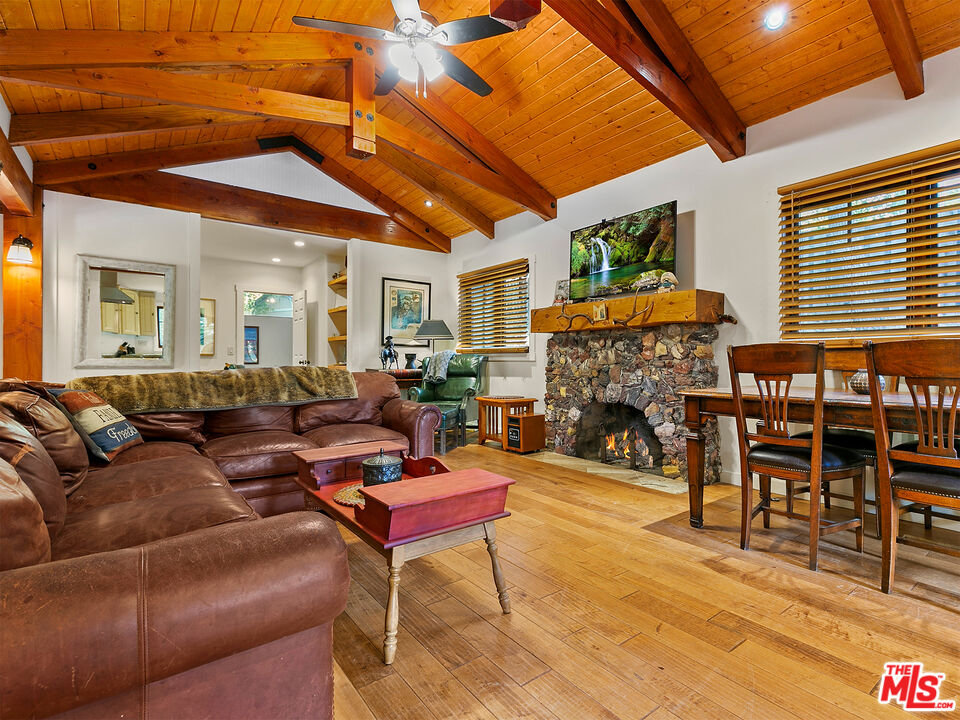 25643 Timpangos Drive Monte Nido, CA 91302 - Photo 13 of 24 a living room with furniture a fireplace and a flat screen tv