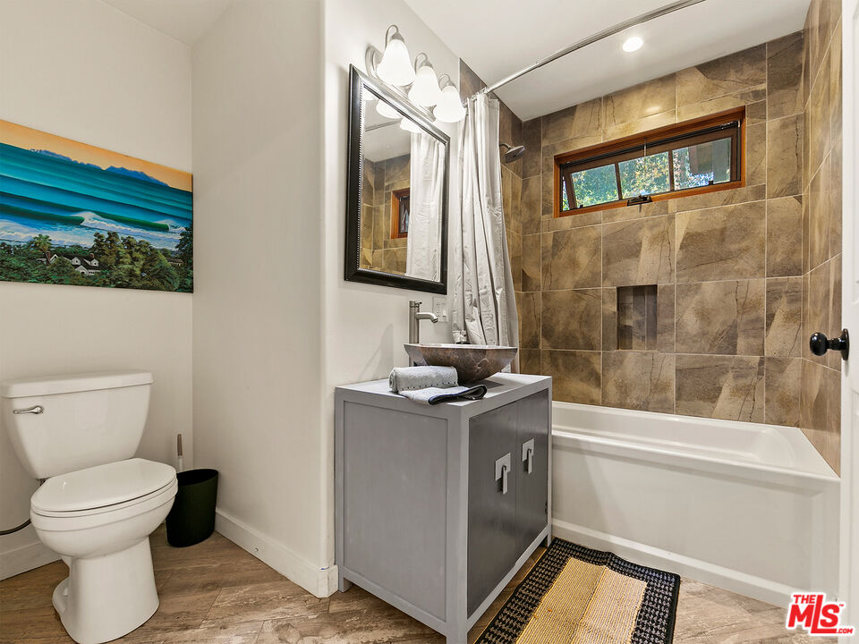 25643 Timpangos Drive Monte Nido, CA 91302 - Photo 23 of 24 a bathroom with a granite countertop sink toilet and shower