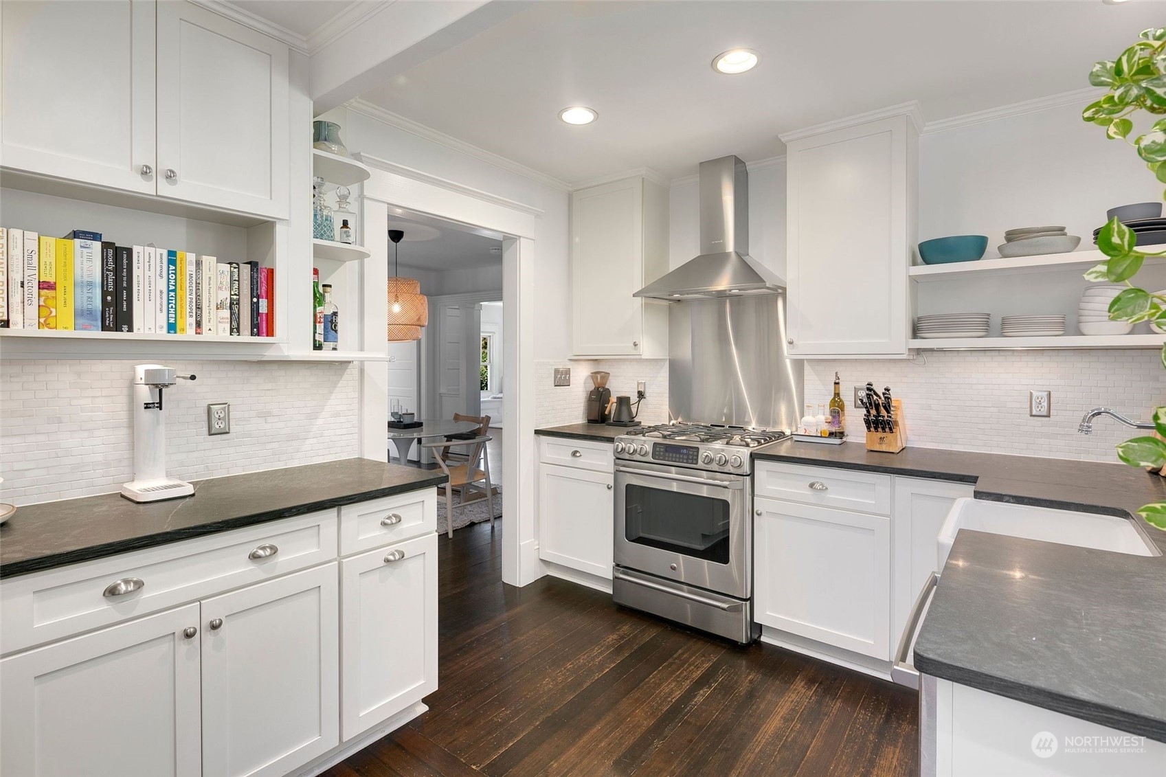 3244 Walnut Avenue Southwest Seattle, WA 98116 - Photo 2 of 40 a kitchen with stainless steel appliances granite countertop a sink dishwasher a stove and white cabinets with wooden floor
