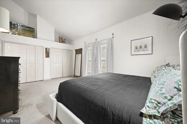 a view of an empty room with wooden floor and stairs