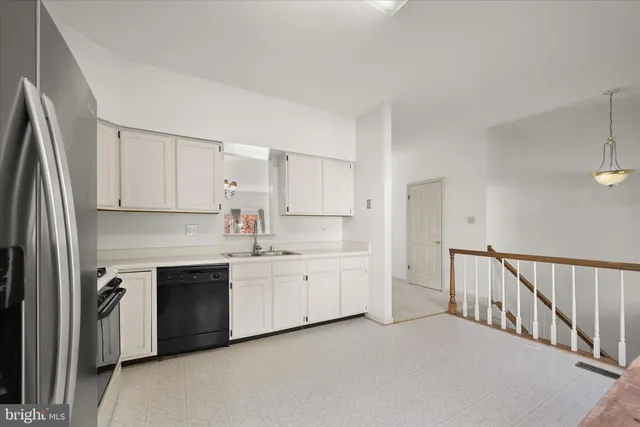 a kitchen with white cabinets a sink stove and refrigerator