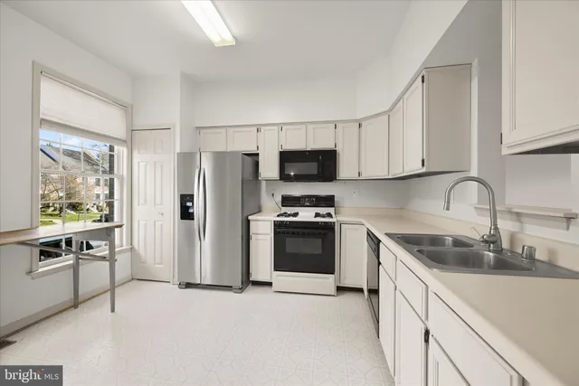 a kitchen with stainless steel appliances a stove a sink a refrigerator and a granite counter tops