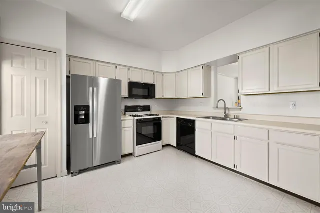 a kitchen with granite countertop white cabinets and stainless steel appliances