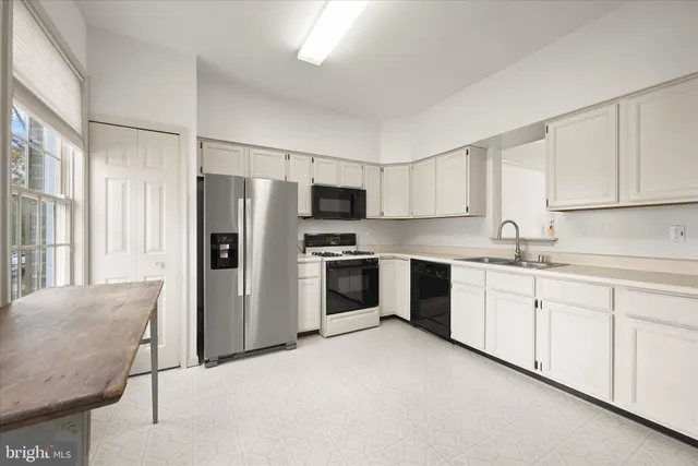 a kitchen with granite countertop white cabinets and stainless steel appliances