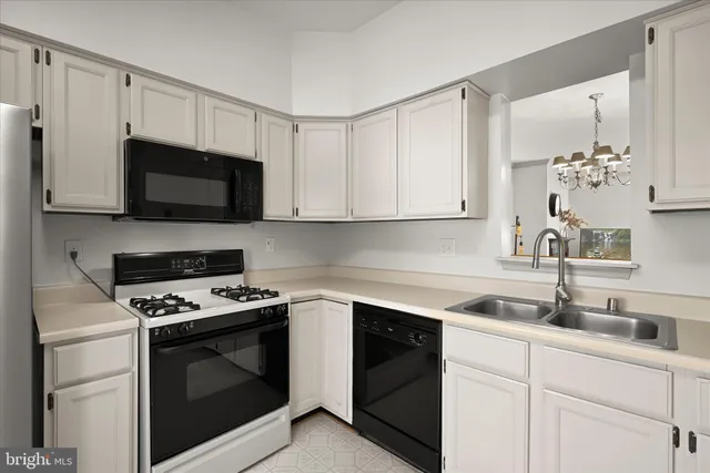 a kitchen with white cabinets and white appliances