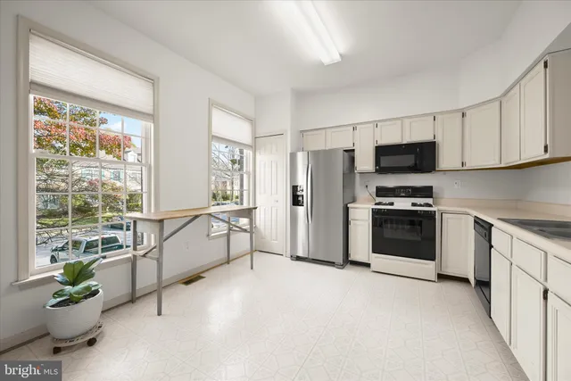 a kitchen with stainless steel appliances a refrigerator sink and stove