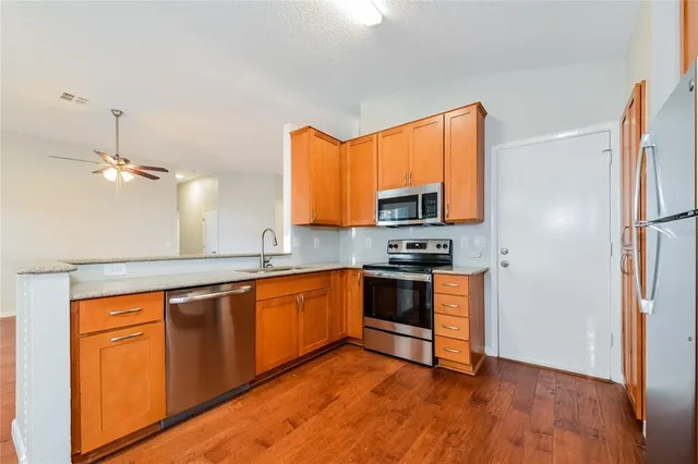 a kitchen with stainless steel appliances granite countertop a stove a sink and a refrigerator