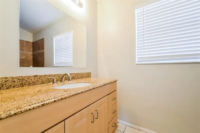 a bathroom with a granite countertop sink and a bathtub