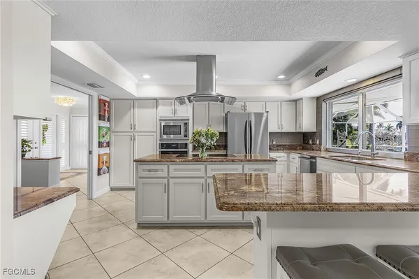 a large kitchen with granite countertop lots of counter space and stainless steel appliances