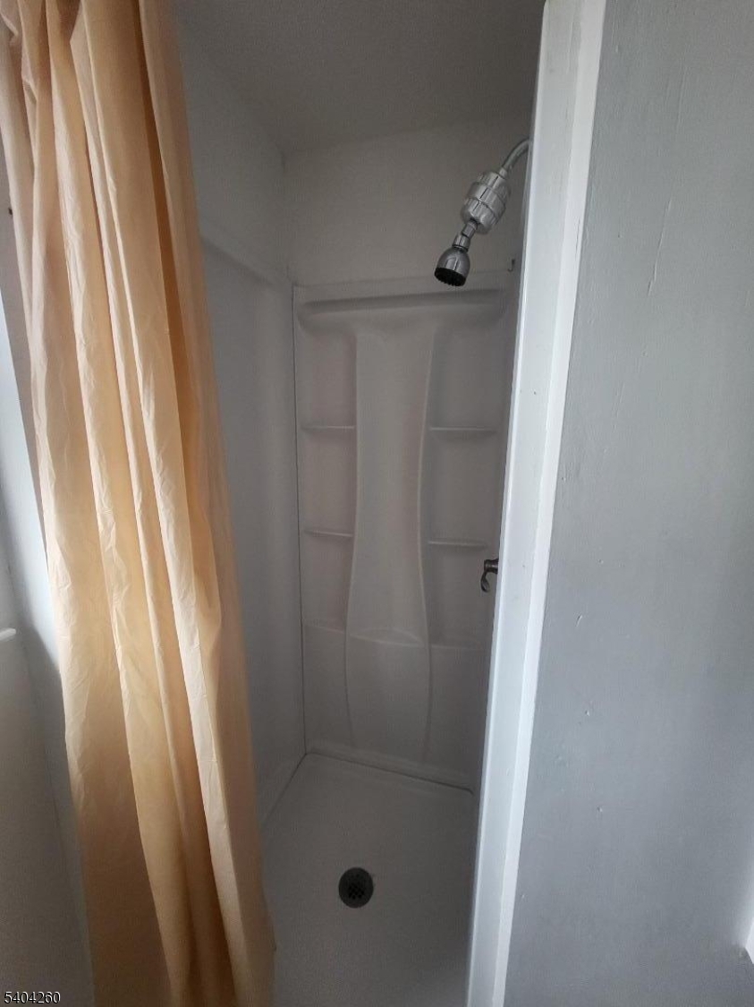 129 Sayre Street Elizabeth, NJ 07208 - Photo 3 of 5 a bathroom with a glass door shower