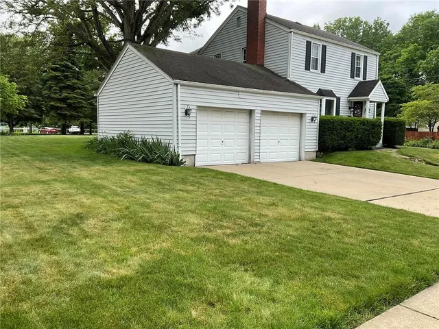 a front view of a house with yard and garage