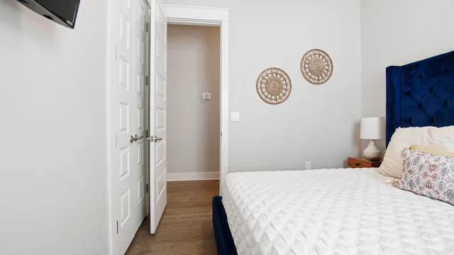 a bedroom with a bed and a window with wooden floor