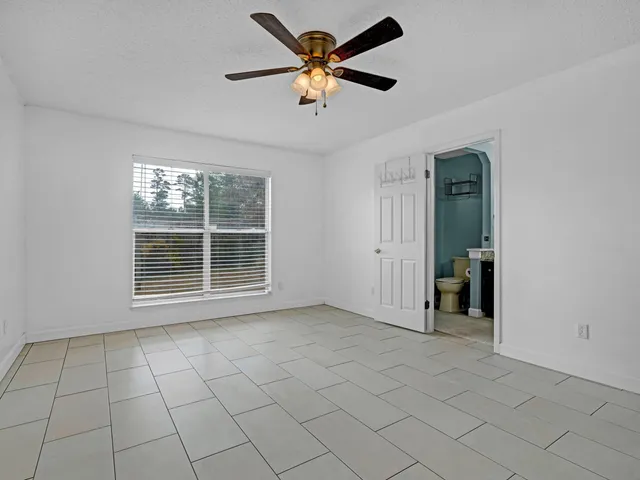 a bedroom with a bed and a ceiling fan