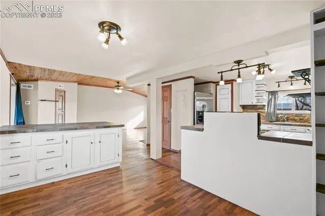 a kitchen with granite countertop a refrigerator a sink and dishwasher