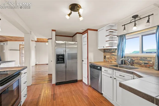 a kitchen with a refrigerator sink and wooden floor